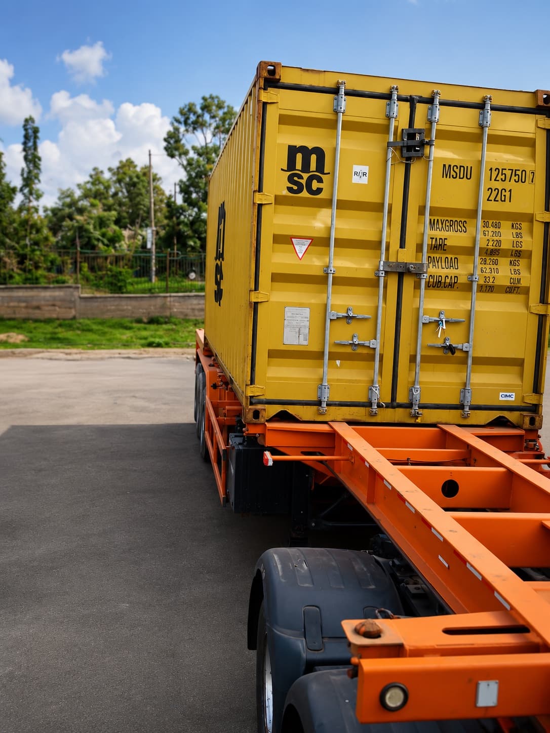Skeletal trailer chassis with a shipping container loaded, showing the exposed frame